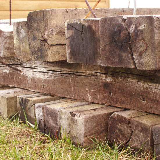 railroad ties stacked on grass